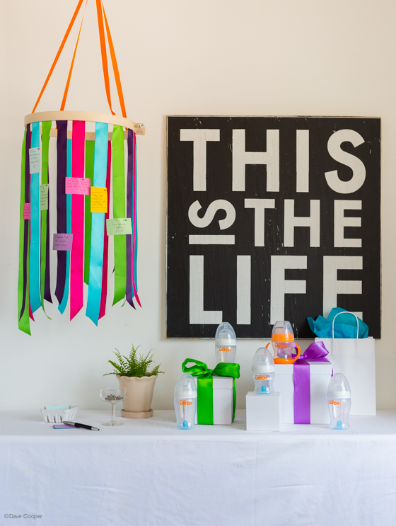 How to make a ribbon chandelier for the gift table. Guests write little notes to the mom, dad and/or baby and attach them to the ribbons. After the party, save the notes for the baby book.